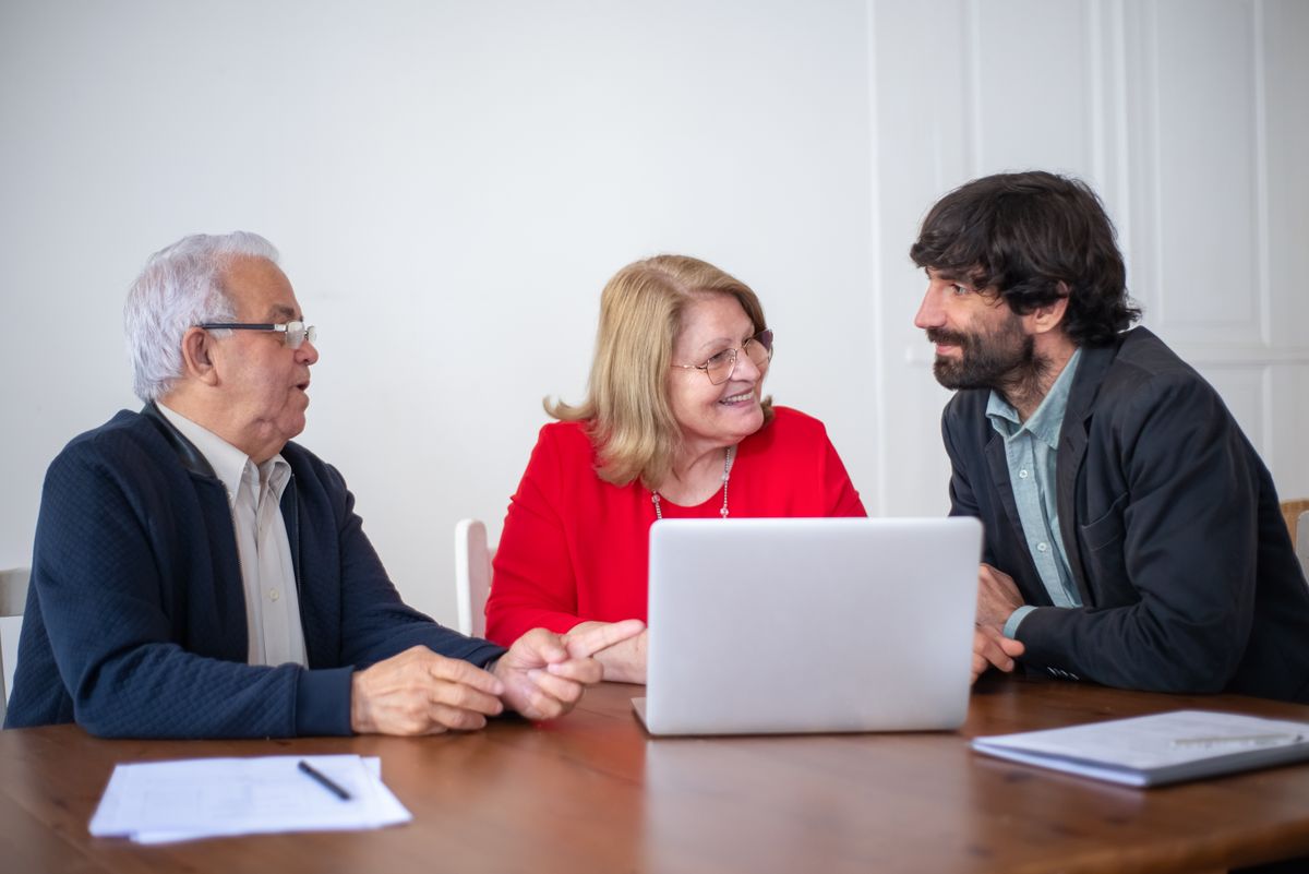 A professional discussing care options with an older couple at a table